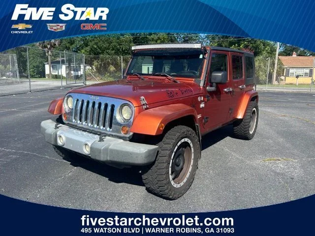 Used 2009 Orange Jeep Unlimited Sahara image 1