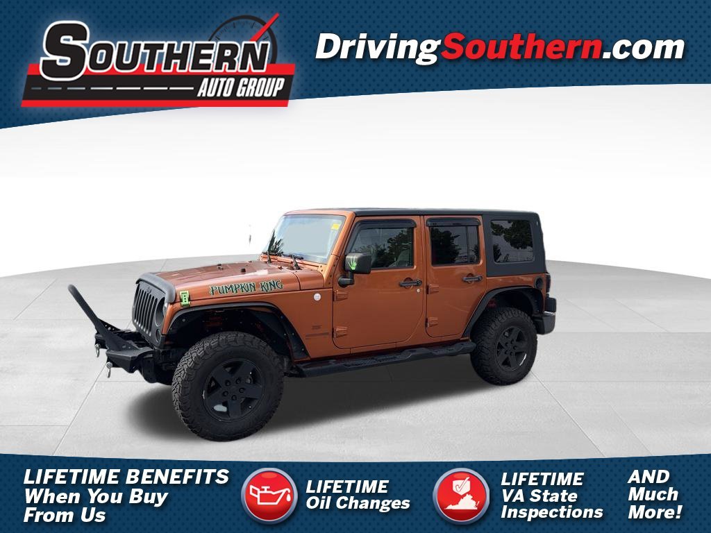 Used 2010 Orange Jeep Unlimited Sport image 1